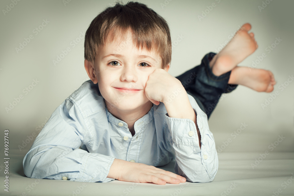 Smiling little boy lying on the floor Smiling little boy lying on the floor