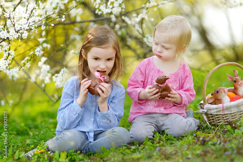 Two girls eating chocolate bunnies on Easter