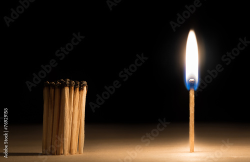 Crowd of burnt  matches standing before match on fire concept of