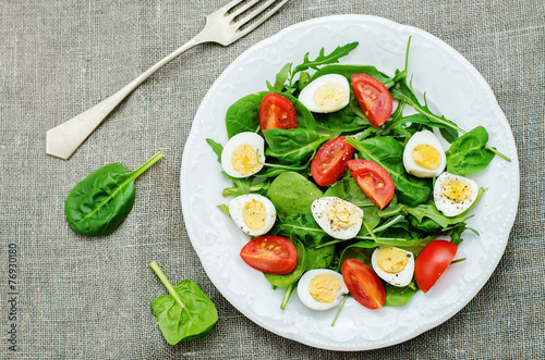 salad with arugula, spinach, tomatoes and eggs.