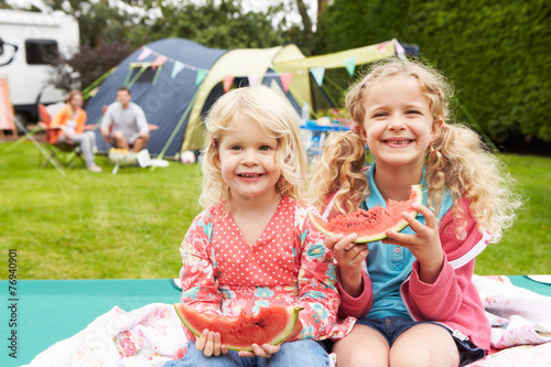 Children Enjoying Picnic Whilst On Family Camping Holiday
