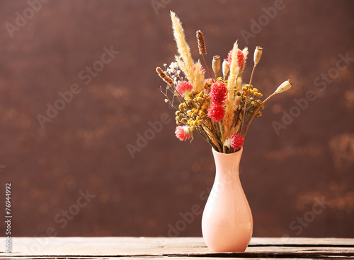 Fototapeta Naklejka Na Ścianę i Meble -  Bouquet of dried flowers in vase on color background