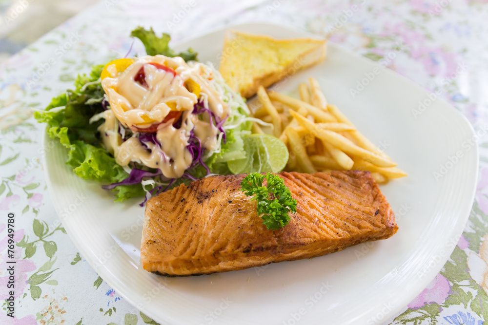 grilled salmon steak with french fried and vegetable salad grilled salmon steak with french fried and vegetable salad