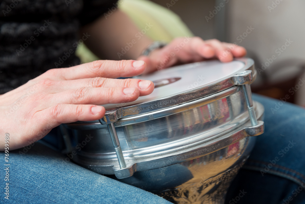 hands playing on small drum