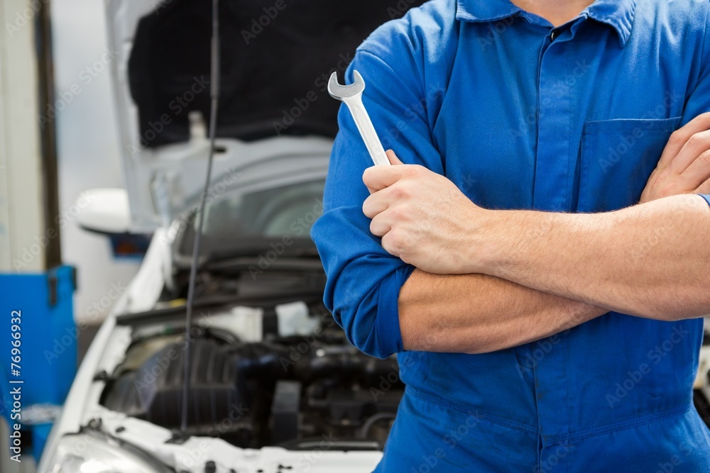 Mechanic holding wrench with crossed arms Mechanic holding wrench with crossed arms