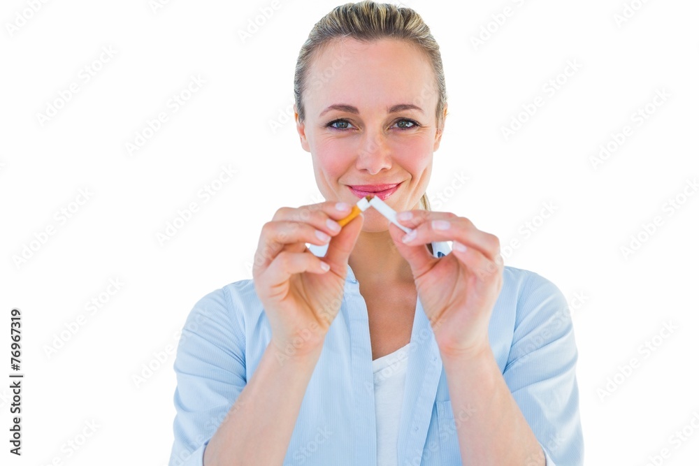Smiling blonde standing and breaking cigarette Smiling blonde standing and breaking cigarette
