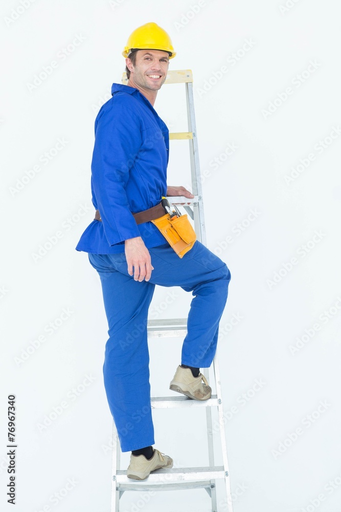 Portrait of repairman climbing step ladder