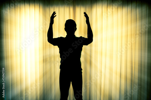 Silhouette man pray with light ray effect background