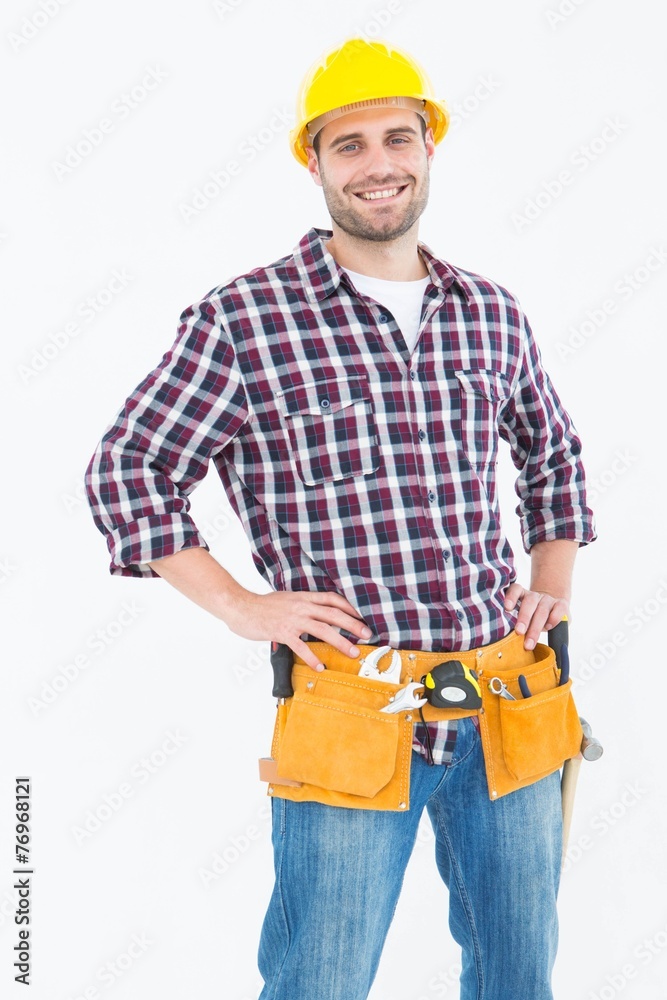 Handyman wearing tool belt while standing hands on hips Handyman wearing tool belt while standing hands on hips