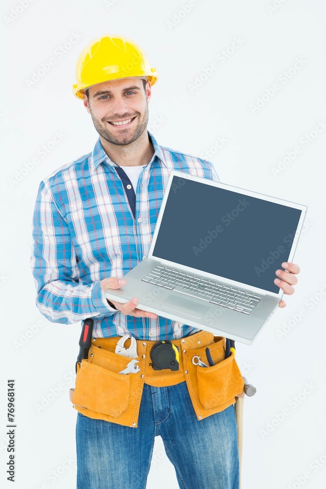 Happy construction worker showing laptop