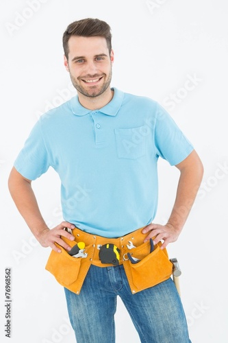 Happy carpenter standing with hands on hips