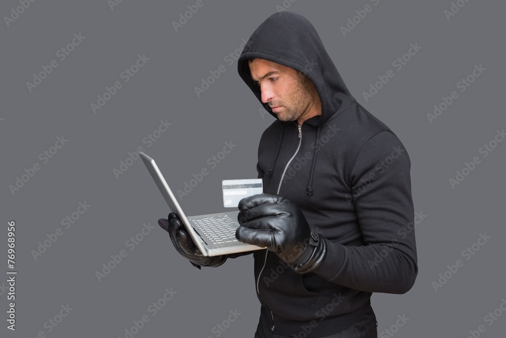 Hacker using laptop to steal identity Hacker using laptop to steal identity