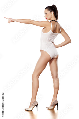 young beautiful lady in white monokini showing direction