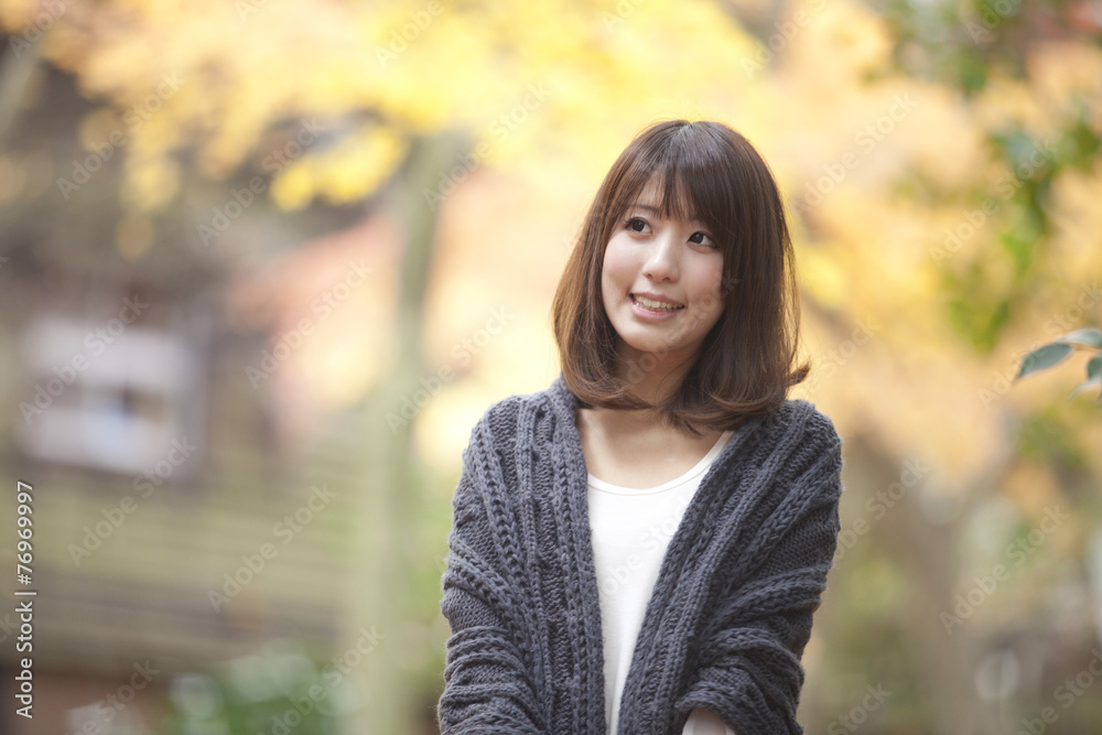 秋の紅葉した公園で立っている女性 秋の紅葉した公園で立っている女性