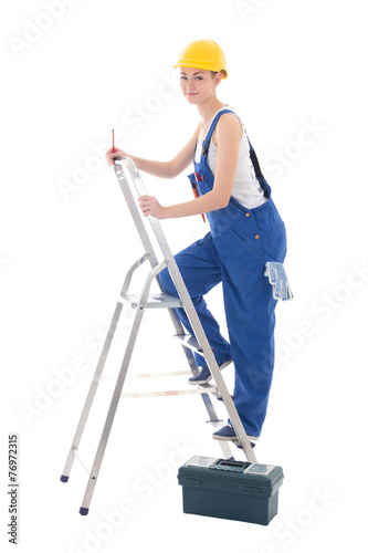 young woman builder in blue coveralls with toolbox, screwdriver