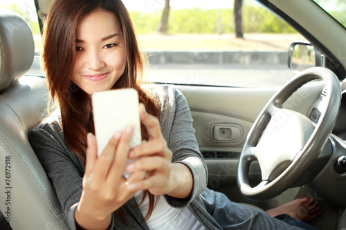 young woman taking selfie in the car