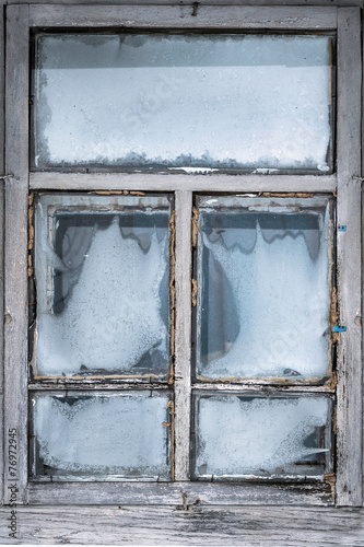 Misted snow-covered window country house