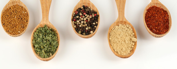 Fototapete Gewürze Different spices and herbs in wooden spoons isolated on white  © Africa Studio