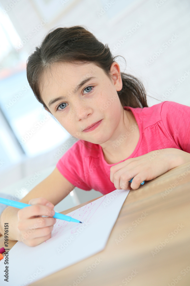Portrait of brunette school girl writing on paper Portrait of brunette school girl writing on paper