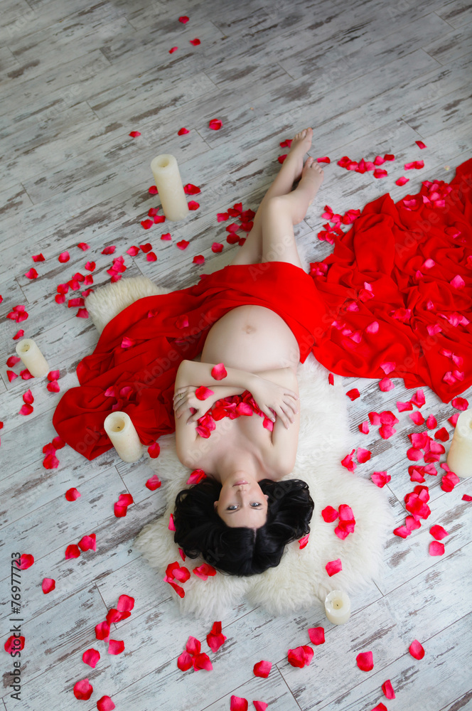 Portrait of a beautiful pregnant woman in red chiffon shawl