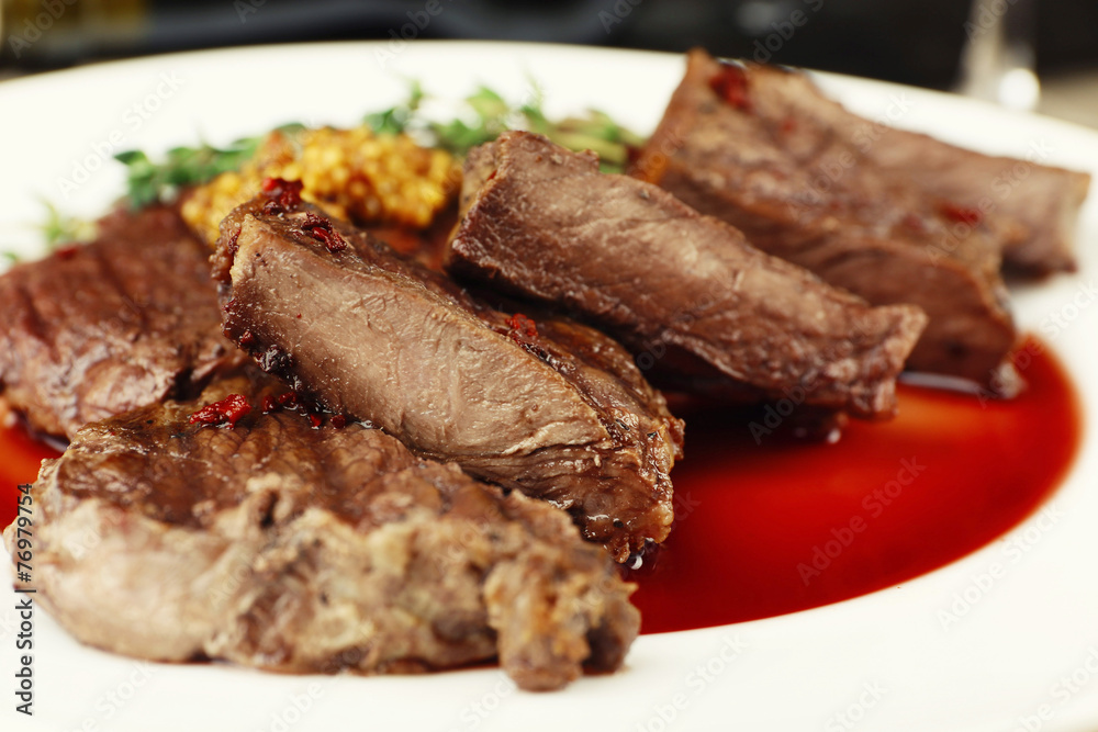 Steak on plate on table close up Steak on plate on table close up