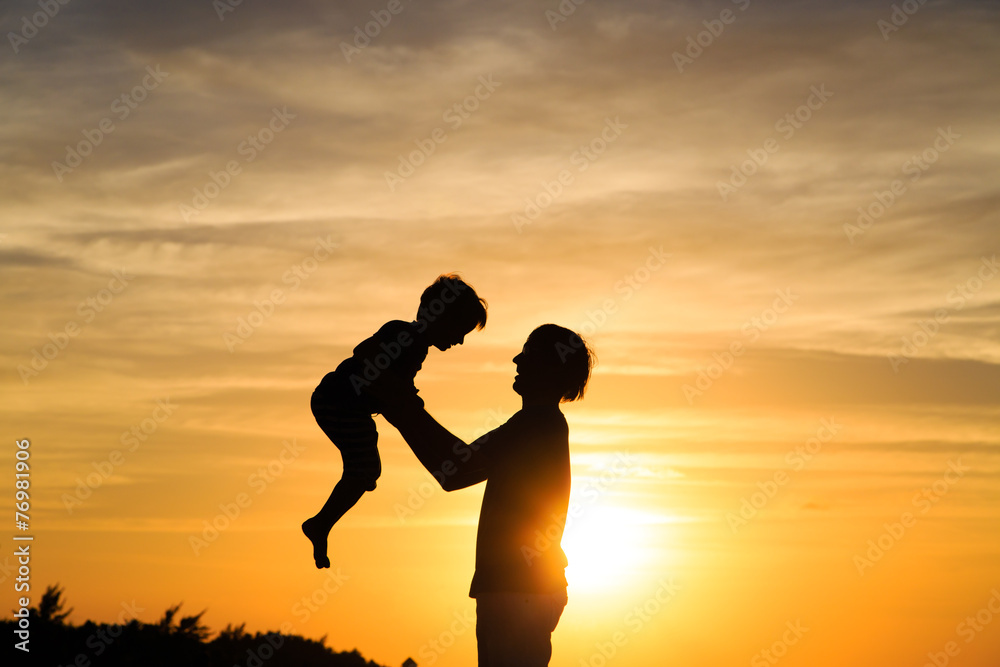 father and son play at sunset
