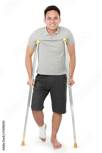 young man with broken leg use crutches