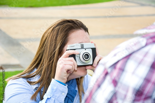Young woman doing a photo to her boyfriend in the park