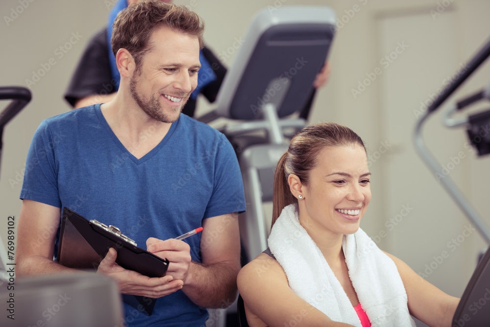 Obraz premium trener w studio fitness rejestruje dane