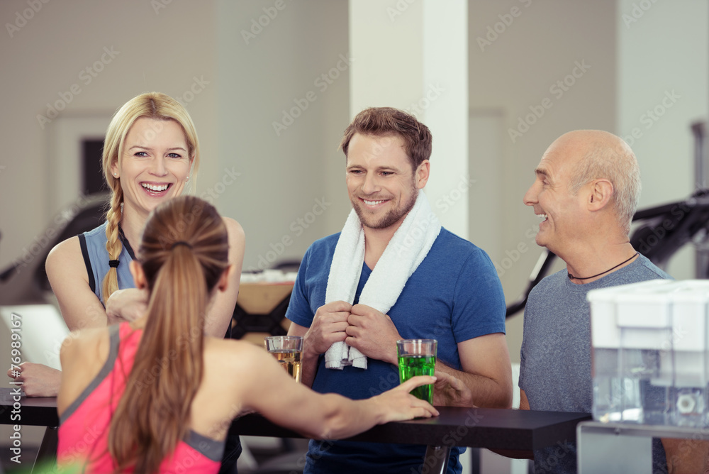 Fototapeta premium lachende gruppe nimmt ein getränk im fitness-studio