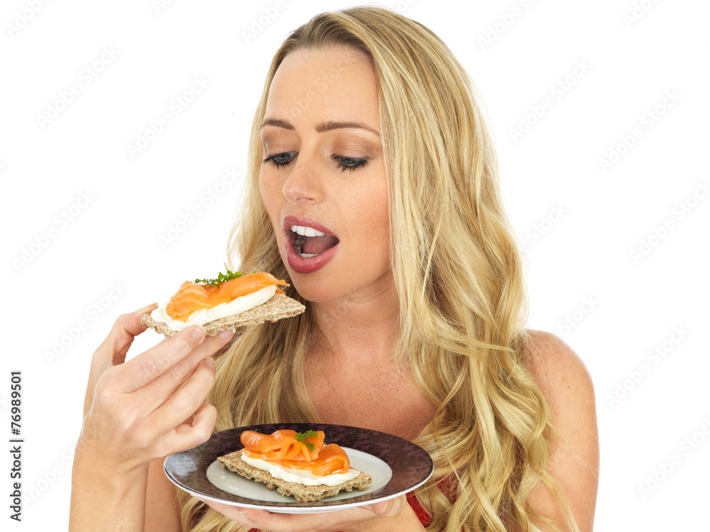 Young Woman Eating Smoked Salmon and Cream Cheese on a Cracker Young Woman Eating Smoked Salmon and Cream Cheese on a Cracker