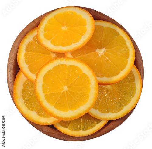 Orange slices in a wooden bowl on a white