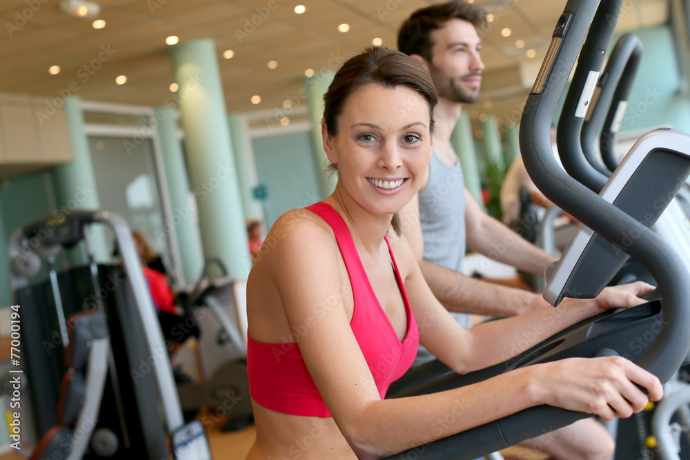 Woman in fitness club using cardio equipment Woman in fitness club using cardio equipment