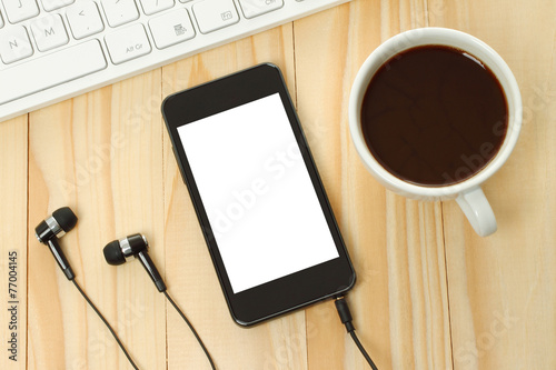 Smart phone with headphones, keyboard and coffee