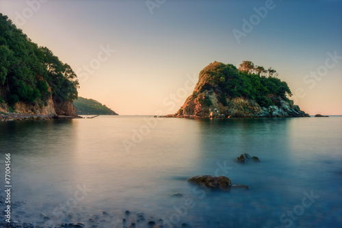 small rocky island while sunrise at ocean in italy