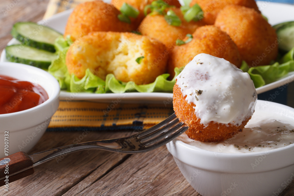 Fried potato balls with sour cream close-up horizontal. Fried potato balls with sour cream close-up horizontal.