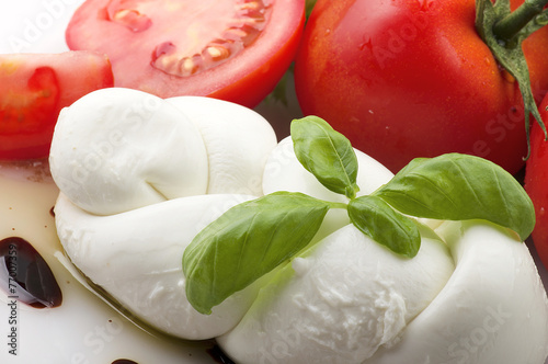 Mozzarella tomatoes and fresh salad on the white