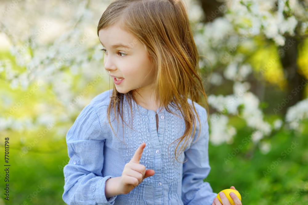Adorable little girl playing in a garden on Easter Adorable little girl playing in a garden on Easter