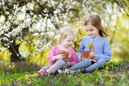 Two little girls playing in a garden on Easter © MNStudio
