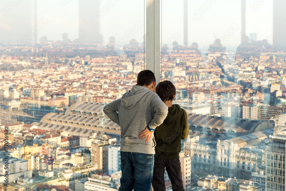 Due bambini guardano la città dalla finestra di un grattacielo Stock Photo  | Adobe Stock