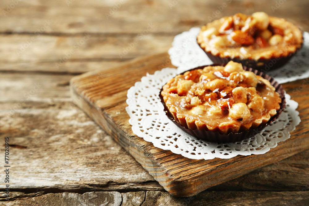 Mini cakes with nuts on wooden background