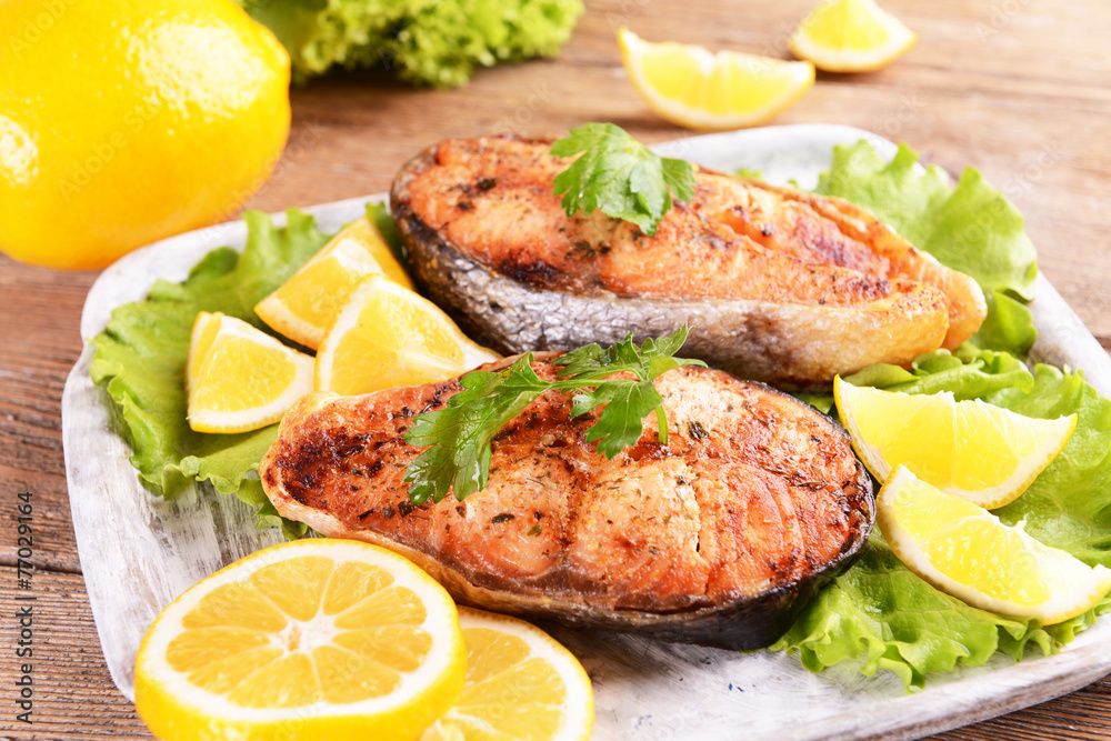 Tasty baked fish on plate on table close-up Tasty baked fish on plate on table close-up
