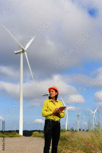 Woman engineer or architect with white safety hat and wind turbi