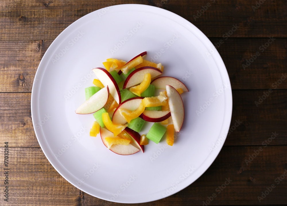 Waldorf salad with salad pepper on plate on wooden background