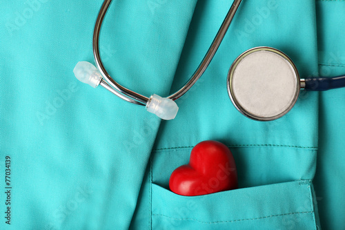 Stethoscope with heart on suit background, close-up