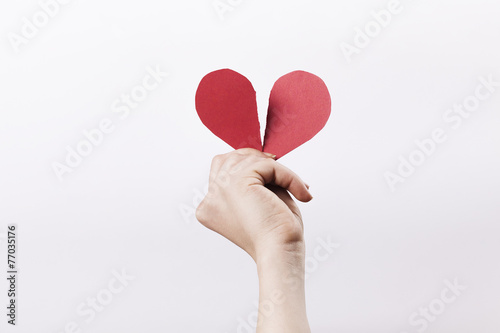Woman hand holding broken paper heart