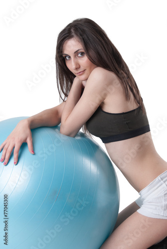 Young athletic woman with blue exercise ball