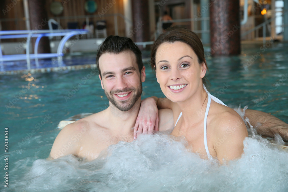 Couple enjoying bath in spa center jacuzzi Couple enjoying bath in spa center jacuzzi