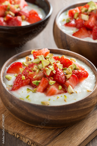 sweet yogurt with fresh strawberries and pistachios in a bowls