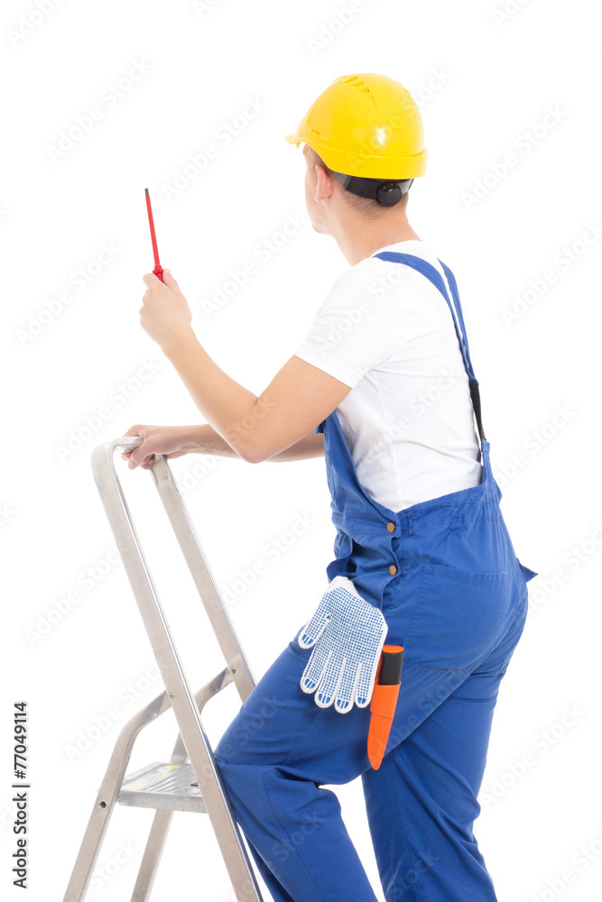 back view of young man builder in blue coveralls with screwdrive back view of young man builder in blue coveralls with screwdrive